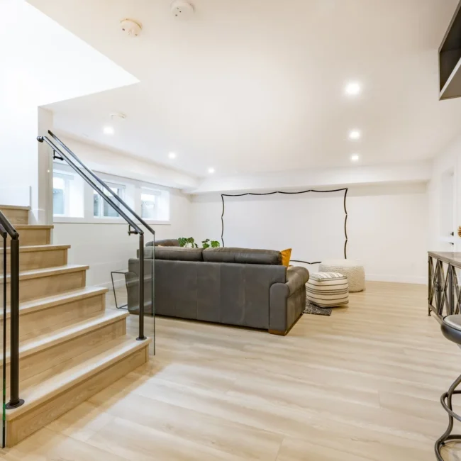 stock-photo-recreation-party-room-with-bar-stairs-with-glass-rails-downstairs-basement-interior-room-with-movie-2275997557-1920w